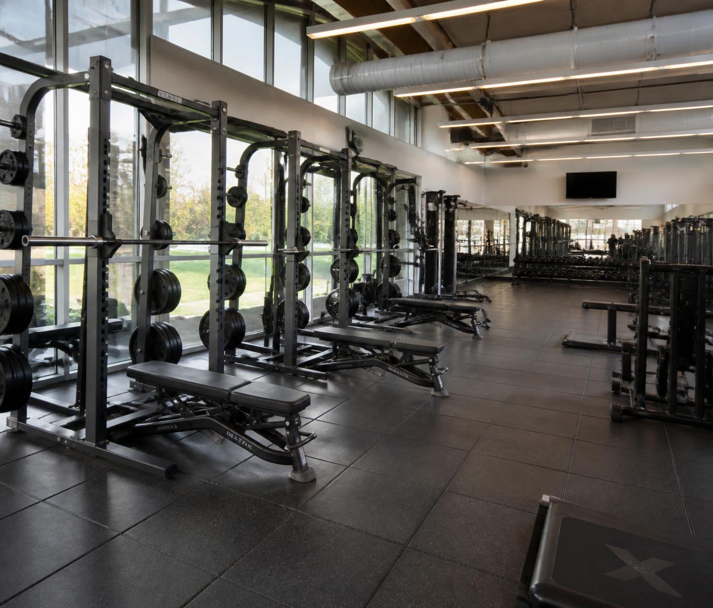 Strength training area with racks and benches at YOUR FITNESS STORY, Pune